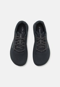 Chaussures de sport noires avec une tige en maille texturée, des lacets ton sur ton, un design bas et une semelle extérieure en caoutchouc durable. Construction légère.