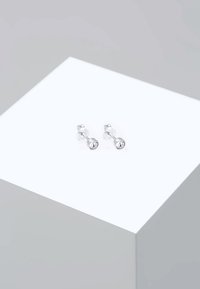 Silberne Ohrstecker verfügen über einen runden, klaren Edelstein in der Mitte, der in einem schlichten, polierten Design mit einer glatten Oberfläche eingearbeitet ist.