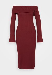 Robe côtelée bordeaux avec un décolleté épaules dénudées, des manches longues et une silhouette ajustée, comprenant une fente latérale pour faciliter les mouvements.