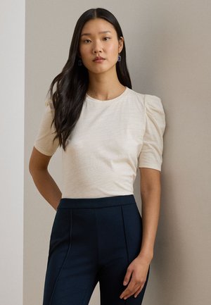 Top s balónikovými rukávmi vyrobený z ľahkej tkaniny, s okrúhlym výstrihom. Kombinovaný s námorníckymi vysoko pásovými nohavicami na mieru.