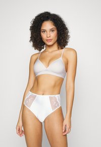 Light grey bralette with thin straps and a soft finish, paired with white high-waisted panties featuring sheer sides and floral embroidery.