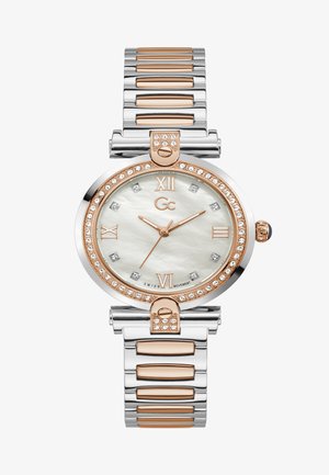 Rund ur med et sølv- og rosaguld rustfrit stålrem, hvid perlemorsskive, diamantdetaljer og romerske tal.