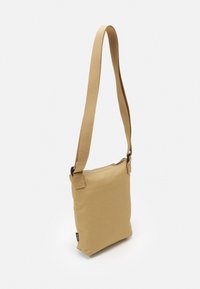 Khaki crossbody taske med et struktureret stof, lynlås lukning og justerbar strop. Minimalistisk rektangulært design. Kompakt og let.