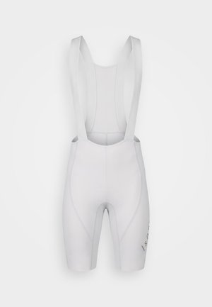 Cuissard de cyclisme blanc avec siège rembourré et bretelles élastiques, présenté sur un fond uni.