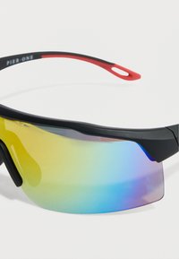 Αθλητικά γυαλιά ηλίου με μαύρο πλαίσιο και κόκκινες πινελιές, με βαθμιδωτούς φακούς που μεταβαίνουν από κίτρινο σε μπλε, καμπυλωτό σχήμα και κομψό σχέδιο.