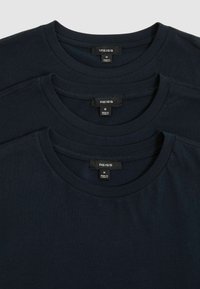 Tricouri din bumbac de culoare bleumarin, aranjate unul peste altul. Fiecare are un decolteu rotund și mâneci scurte standard. Etichete vizibile în interior: marcă și mărimea M.