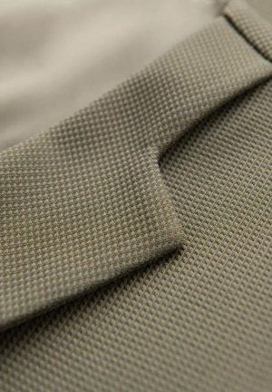 Getextureerde stof in gedempt groen met een ruitpatroon, met een gevouwen sectie die zacht, flexibel materiaal en een gladde afwerking toont.