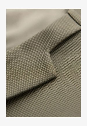 Getextureerde stof in gedempt groen met een ruitpatroon, met een gevouwen sectie die zacht, flexibel materiaal en een gladde afwerking toont.