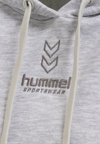 Grå huvtröja i mjukt tyg med en känguruficka, featuring ljusbeige snoddar och broderad logotyp med chevrondetaljer.
