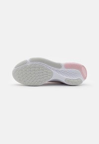 Semelle de chaussure de sport élégante en gris clair et blanc, avec un motif en caoutchouc texturé et des accents rose pâle au talon et au milieu de la semelle.