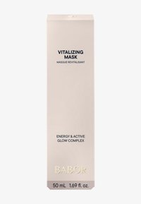 Masque vitalisant emballé dans une boîte rectangulaire haute de couleur rose pâle. Présente un texte noir décrivant le nom du produit et ses bienfaits, avec des accents dorés.