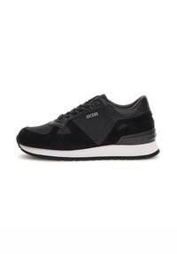 Chaussure de sport noire avec un mélange de matériaux lisses et texturés, dotée d'une semelle intermédiaire blanche, d'un système de laçage et du logo « Guess » sur le côté.