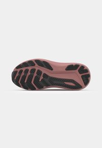 Semelle de chaussure de sport avec un intercalaire rose et une semelle extérieure en caoutchouc noir, dotée d'un motif texturé et de motifs en relief pour une meilleure adhérence.