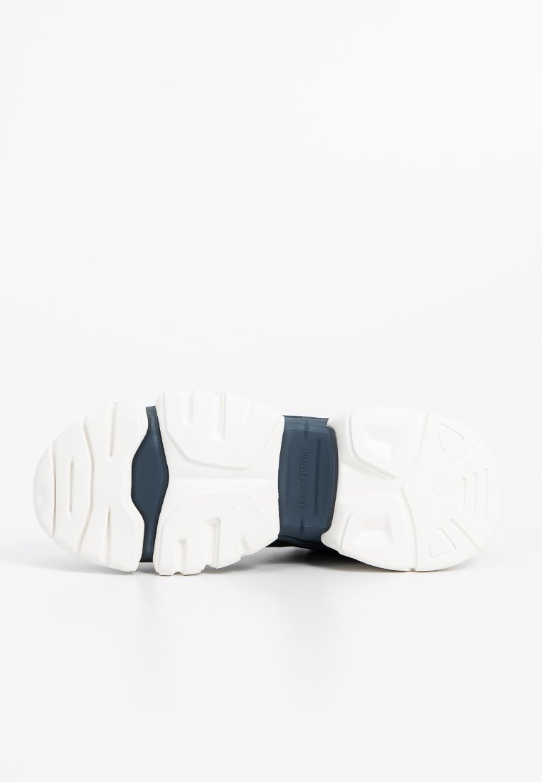 Sneaker-Sohle mit einer strukturierten weißen Gummisohle, die mit Rillen und Griffen versehen ist, ergänzt von einem marineblauen oberen Bereich für zusätzlichen Stil.