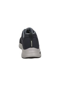 Zapatilla deportiva para hombre en malla azul marino con acentos grises. Cuenta con una suela acolchada, un collar acolchado y una cinta en el talón para facilitar el uso.