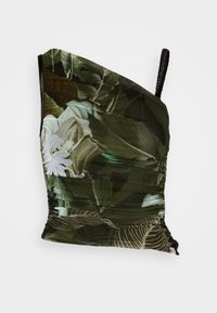 Top asymétrique avec un motif de feuilles vertes, en tissu texturé et avec des détails froncés. Bretelle réglable avec accent noir.