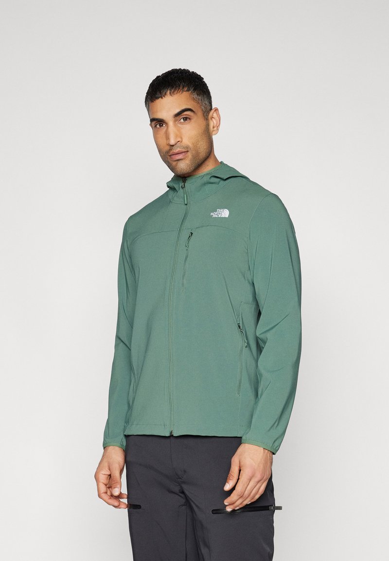 Chaqueta verde con capucha hecha de un tejido ligero, con cremallera frontal y acento de logo. Presenta una textura suave y un diseño ajustado.