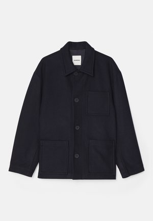 Tummansininen villasekoitteinen takki, jossa on kauluspäänti, nappikiinnitys ja kaksi etutaskua. Sileä pinta ja yksinkertainen muotoilu.