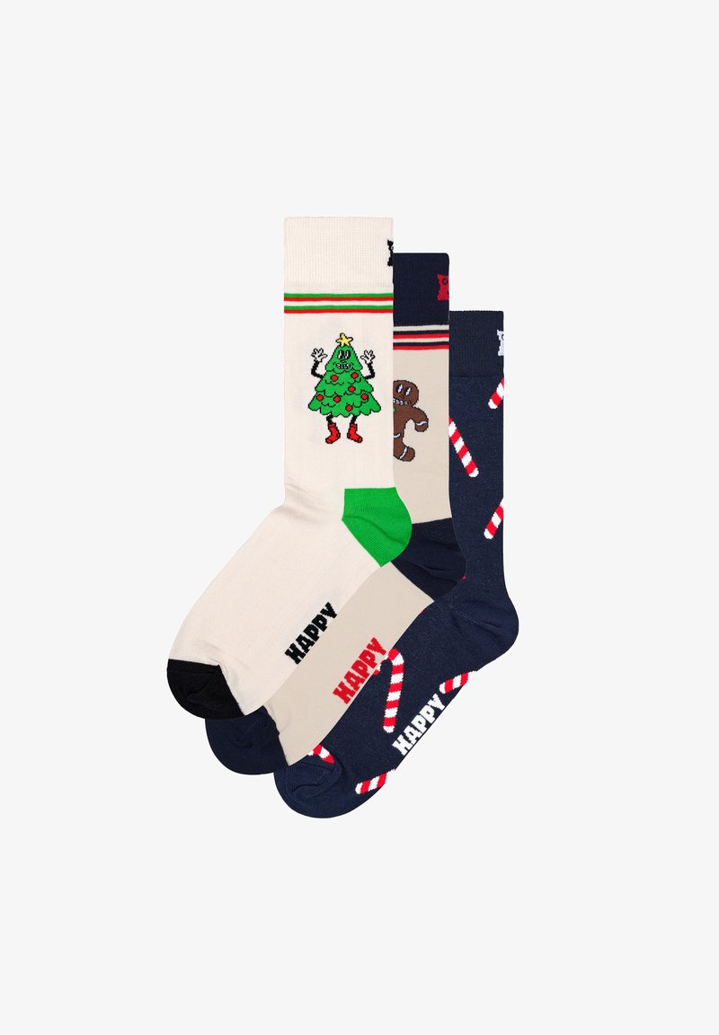 Drie paar sokken: beige met een groen kerstboomontwerp, bruin met een peperkoekenmannetje en marineblauw met een patroon van zuurstokken.