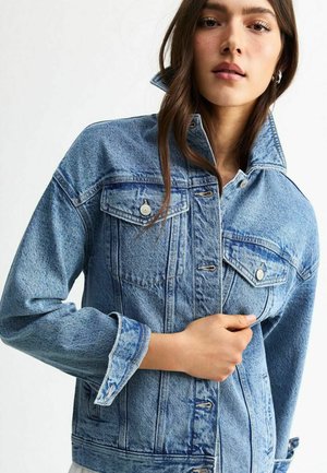 Light blue denim jacket with a high collar, front button closure, and two chest pockets. Features a slightly faded texture.