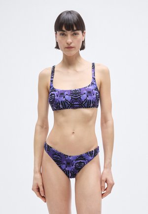 Fioletowy bikini w wzory z kwadratowym dekoltem, cienkimi ramiączkami i dopasowanymi, niskimi majtkami z fakturą.