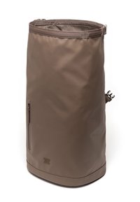 Sac à dos marron résistant à l'eau, de forme cylindrique, avec une surface mate lisse, une poche zippée sur le côté et le logo Herschel en bas.