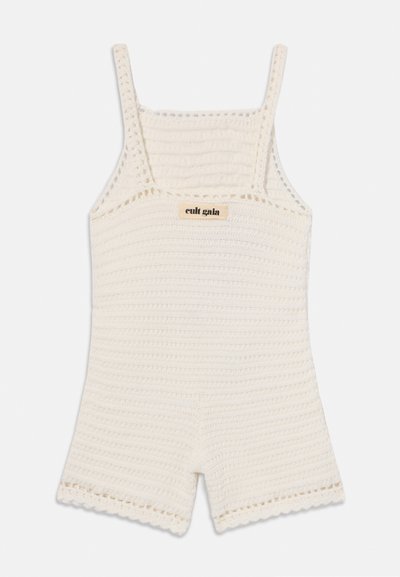 Crocheted romper in cream, featuring thin straps, a textured pattern, and scalloped edges. Logo tag visible on the front.