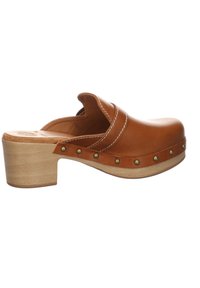 Sabot marron en cuir à enfiler avec talon bloc en bois et clous en laiton le long du bord de la semelle, avec des coutures blanches sur la tige.