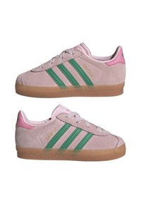 Baskets Adidas Gazelle en daim rose avec des bandes vertes, semelles en gomme et languettes roses au talon, montrées de chaque côté.