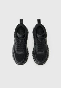 Schwarze Sportschuhe mit einem strukturierten Mesh-Obermaterial und einer geometrisch gemusterten Sohle. Verfügt über Schnürsenkel, Zugschlaufen und ein elegantes Design.