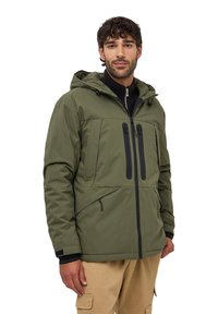 Giacca imbottita verde oliva con cappuccio, dotata di due tasche frontali con zip, zip nere e colletto alto con fodera interna testurizzata.