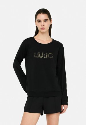 Felpa nera a maniche lunghe con scollatura rotonda e logo "LIU-JO" scintillante sul davanti. Presenta una vestibilità rilassata e polsini a costine.