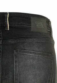Schwarze Denim-Jeans verfügen über eine rechteckige Gesäßtasche, Kontrastnähte und ein schwarzes Lederlabel mit "camel active"-Branding.
