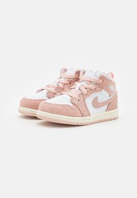 Sneaker mid-top in suede rosa e pelle bianca con punta perforata e dettagli testurizzati; presenta lacci rosa e un logo sul lato.