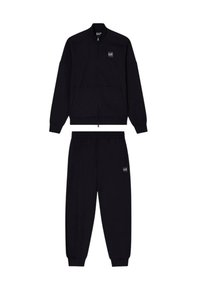 Chaqueta negra con cremallera y cuello alto, acompañada de pantalones jogger a juego que cuentan con cinturilla elástica y parche con logo.