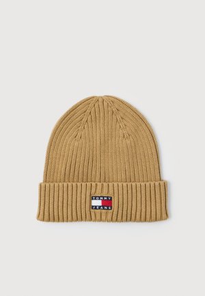Beanie a coste color beige con risvolto, caratterizzato da una piccola etichetta rettangolare con logo Tommy Jeans nei colori rosso, bianco e blu.