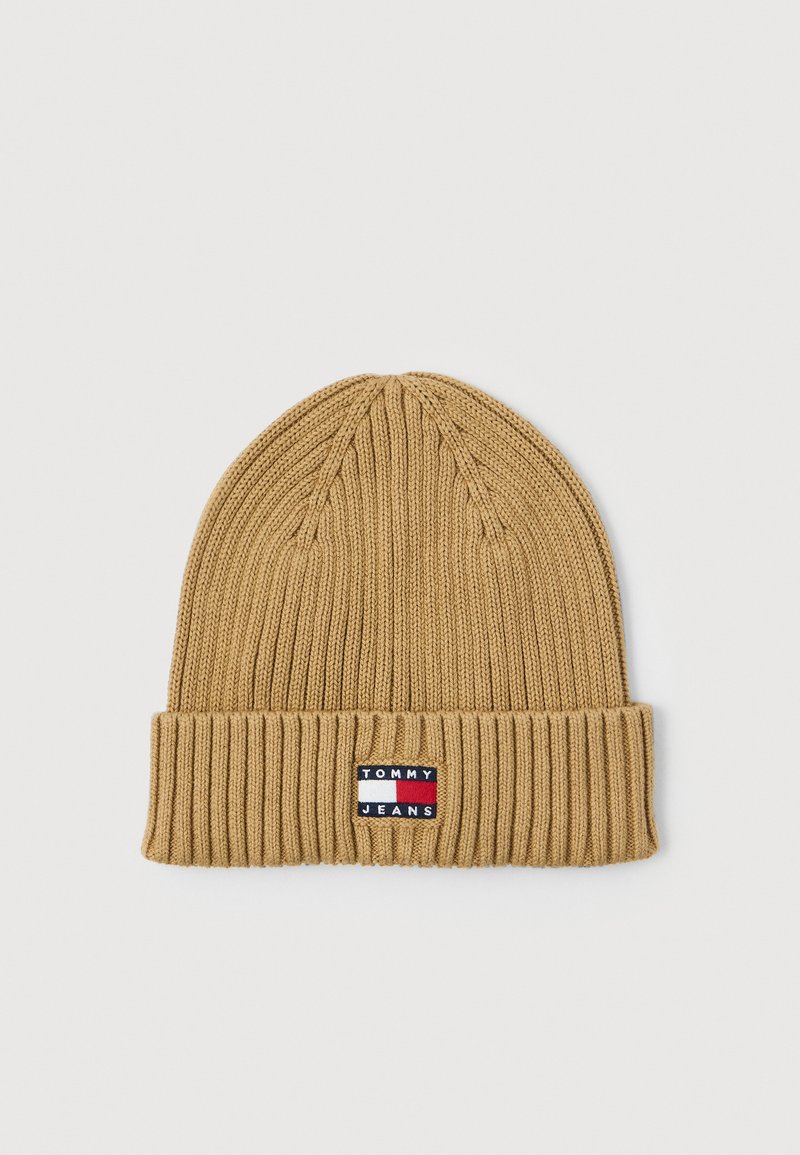 Beanie a coste color beige con risvolto, caratterizzato da una piccola etichetta rettangolare con logo Tommy Jeans nei colori rosso, bianco e blu.