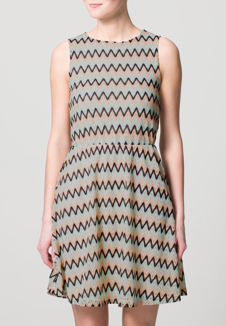 Abito senza maniche con un motivo a zigzag nei toni del beige, nero e teal. La gonna ampia presenta una vita aderente e una trama liscia.