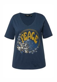 Námořnická modrá bavlněná tričko s výstřihem do V, které obsahuje velký grafický nápis "PEACE" a květinový design s flitry a zakřivenými liniemi v žluté a bílé barvě.