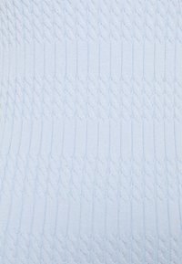 Jasnoniebieska dzianina swetra z wzorem w warkocze, z teksturowanymi detalami oraz gładkimi sekcjami ściągacza w miękkim, równym splocie.