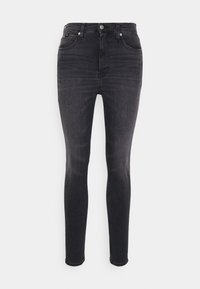 Pantalones ajustados de mezclilla negros con un corte ceñido, que destacan por su diseño clásico de cinco bolsillos y herrajes metálicos en tono plateado. Sin patrones visibles.