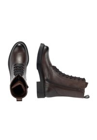 Stivaletti alla caviglia in pelle marrone con punta arrotondata, chiusura frontale con lacci, cerniera laterale e suola spessa nera. Presentano una texture liscia e dettagli di design minimalisti.