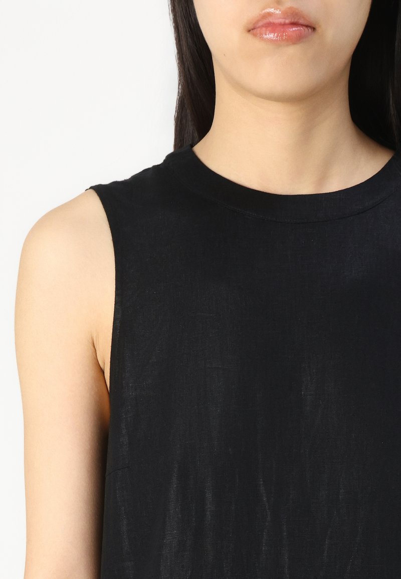 Ärmelloses schwarzes Top mit Rundhalsausschnitt, aus einem leichten Stoff gefertigt; hat eine glatte Textur und minimale Nähte.