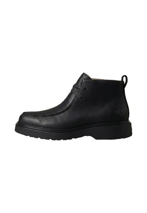 Černá kožená kotníková bota se šněrováním, silnou gumovou podrážkou, poutkem na patě a jemně raženým logem na boku.