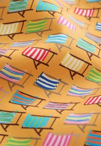 Motif de chaises de plage rayées colorées sur un fond en tissu orange, avec diverses combinaisons de couleurs et des cadres en bois.