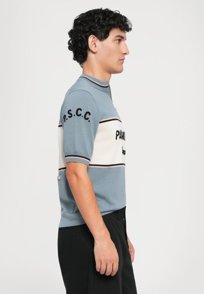 Polo de punto de manga corta en azul claro y blanco con acentos en negro, con texto en la manga y un cuello con cremallera. Tejido texturizado.