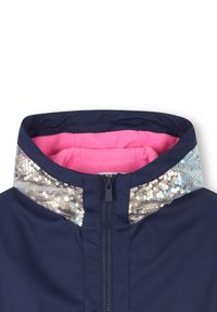 Giacca di marinaretto con rivestimento interno in pile rosa e colletto con paillettes argento. Presenta una zip frontale e una texture liscia.