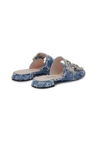 Blue denim slide sandals featuring frayed edges, decorative rhinestone embellishments, and a low, flat sole.