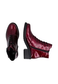 Bottines en cuir verni rouge avec talon bloc, devant à lacets et fermeture éclair latérale. Texture lisse et fini brillant.