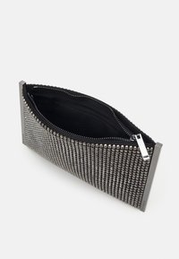 Metalická kabelka s stříbrnými hroty, černou látkovou podšívkou a zipovým uzávěrem. Obdélníkový tvar s elegantními kovovými akcenty.